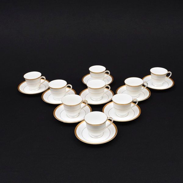 Nove xícaras com pires de café em porcelana japonesa Noritake na cor branca com frisos dourados. Alt. 7 cm.