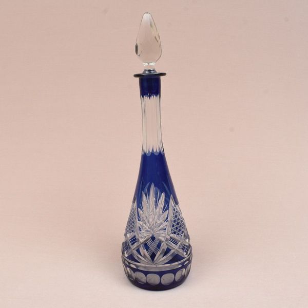 Licoreira europeia de cristal azul overlay lapidado com elementos geométricos e facetas dedão. Alt. 41 cm.