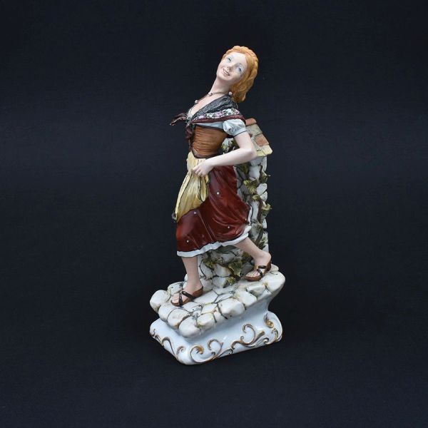 Capo di Monti. Escultura italiana em porcelana policromada representando figura de camponesa . Alt. 38 cm.