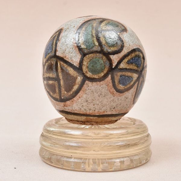 Brennand. Bola decorativa de cerâmica policromada. Base adaptada em cristal translúcido. Alt. 8 cm.