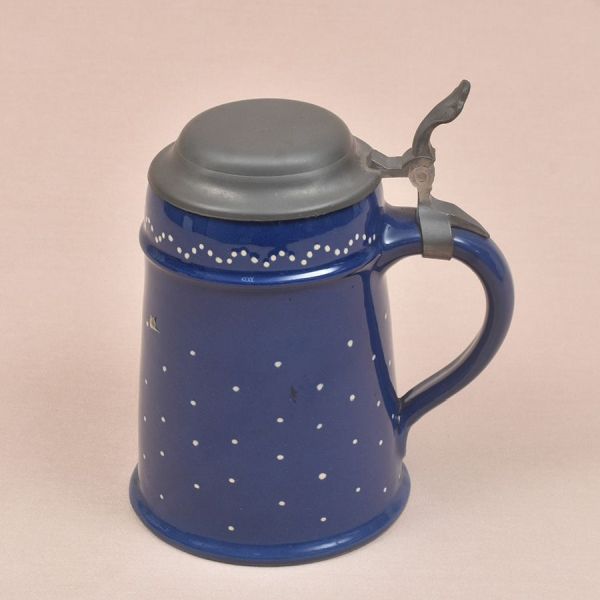 Tankard alemão de porcelana na cor azul com poás em branco. Tampa e alça em pewter. Alt. 19 cm.