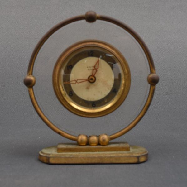Relógio francês de mesa da marca `Bayard` de bronze dourado. Formato circular. Alt. 15 cm.