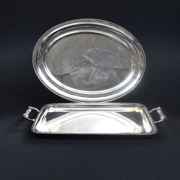 Uma bandeja retangular e uma travessa oval prateadas. Med. e 51 x 33 cm e 49 x 37cm.