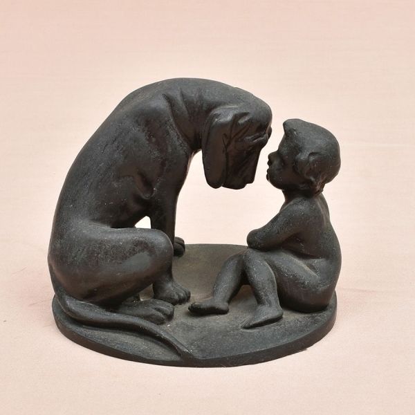 Escultura europeia de bronze representando cachorro com uma criança. Alt. 12 cm.