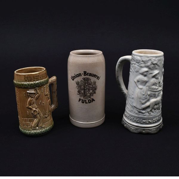Três canecas holandesas de faiança de diferentes decorações. Alt. 20,20 e 16 cm.