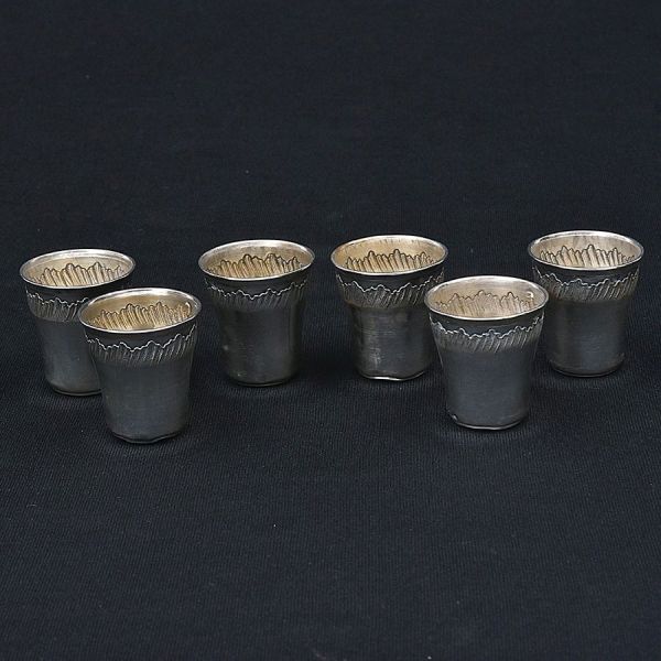 Seis copinhos de prata europeia com delicado cinzel. Alt. 4 cm. Peso: 50g.