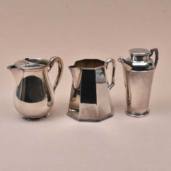 Duas jarras e um bule prateados diversos. Alt. 21, 18 e 17 cm.
