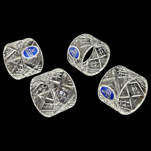 Conjunto de 4 anéis de guardanapos em cristal lapidado á mão da renomada marca britânica Royal Doulton. Acompanha sua embalagem original com tecido acetinado azul. 4,5 x 3 cm altura cada.