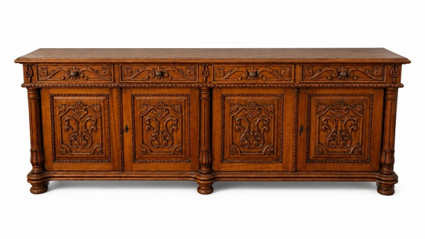 Grande buffet aparador executado em madeira de cerejeira maciça e folheada. Corpo inferior composto por 4 portas almofadadas com expressivos entalhes florais em alto-relevo e fechaduras centrais. Part