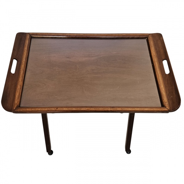 Buther`s tray fixa, de mogno, tampo recoberto de vidro, com abas laterais com pega, Pernas altas em X, pés em rodízio. 72 x 44 x 82 cm de altura.