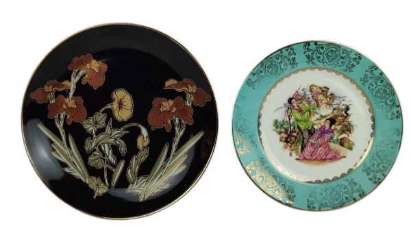 Dois pratos decorativos em porcelana, sendo um com marca da manufatura GEB, tendo ao centro cena de jardim com gueixas, e outro medalhão com marca da manufatura A&J Collection  e tendo ao centro orquídeas em policromia. Diâmts. 26cm e 29,5cm.