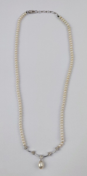 Colar de perolas, de uma volta, com ouro branco 750 e 15 diamantes. Comp. aberto 45cm. Este item não se encontra no local do leilão.