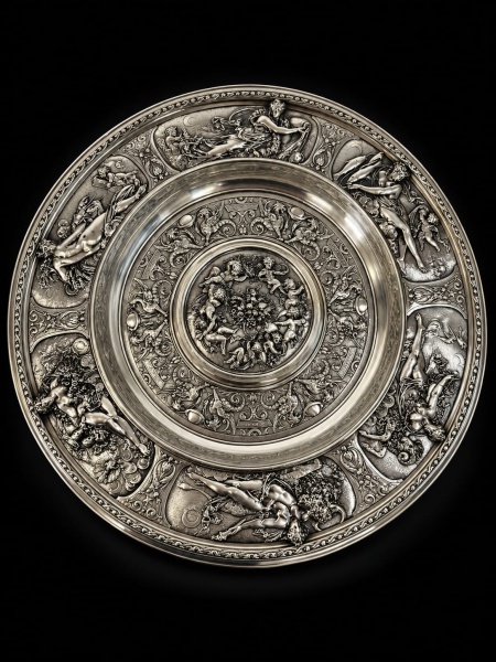 Belíssimo medalhão circular em prata inglesa, profusamente decorada em relevo com borda com figuras