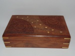 Caixa em madeira nobre, ricamente entalhada e detalhes em metal dourado e interior forrado com veludo vermelho. Tamanho: 6,5 x 25,5 x 015 cm.