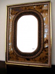 Espelho bisotée ovalado, com moldura dupla retangular. 82 x 61 cm.