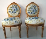 Par de cadeiras, estilo Luis XVI, de madeira nobre, entalhada, estofamento floral. 55 x 100 cm altura.