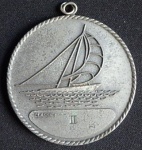 Medalha em Metal Prateado  - ANVERSO - Parte central barco a vela sobre as ondas - REVERSO - Inscrição Sul América Cup Guilherme Roessler . Diam.60mm