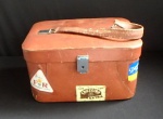 Antiga e interessante maleta de couro marrom com adesivos de época e chave, apresentando marcas de uso. Med. 30cm x 20cm x 17cm