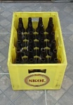 Engradado  cervejaria Skol com 24 garrafas vazias policromia amarela.