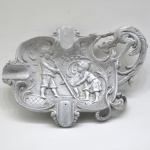 Cinzeiro em Aluminio Fundido com Crianças e Figura Mitologica em Alto relevo no seu interior. Medida: 17,5 x 13 cm.