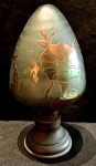 RAVAGNANI-Pinha em pasta de vidro na tonalidade âmbar com desenhos florais e base em metal , medindo 24 cm alt. Não contém assinatura.