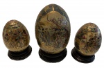 PORCELANA ORIENTAL-Lote contendo 3 ovos de porcelana oriental, lindamente pintados em relevo, com incrível riqueza de detalhes , bases de madeira nobre, medindo 22 , 17 e 12 cm alt.