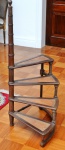 Escada para biblioteca com quatro degraus concêntricos (63 cm) em madeira forrada em couro pirogravado com dourado. Altura total do apoio de mão 120 cm. Comprimento do degrau 68 cm.