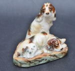 BEAGLES. Grupo escultórico formado por dois cachorros de porcelana. Medindo 11,5 x 12,5 cm.