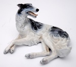 ROSENTHAL  - GALGO. Pequena estatueta de porcelana representando cachorro sentado na cor branca e preto. Marcado no fundo. Medidas 9 x 14 cm.
