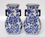 Par de vasos chineses com decoração em azul sobre branco de motivação vegetalista. Alças laterais em azul petróleo. Altura 30 cm, comprimento 19 cm.