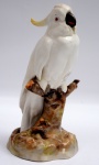 PASSAU SÉCULO XX  - Escultura de porcelana alemã representando pássaro pousado em tronco de árvore. Manufatura da cidade de Passau do estado da Baviera. Marca da manufatura no fundo da peça. Altura 28 cm .