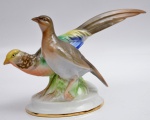 BAVIERA SÉCULO XX - Grupo escultórico de porcelana policromada, representando pássaros. Marca da manufaturada "Gerold Porzellan Bavaria". Altura 14,5 cm, comprimento 25 cm.