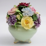 Enfeite de mesa em porcelana representando caso com flores. Marcado ao fundo. Altura 14 cm. Com trincado.