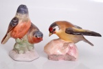 Duas estatuetas de porcelana representando pássaros. Marcas de manufatura ao fundo. Medida maior: 6,5 cm.