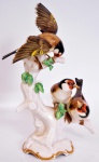 HUTSCHENRUNTHER -  Grupo escultórico de porcelana representando pássaros. Marcado no fundo. Altura 27 cm. Asa com pequeno bicado.