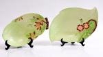 Dois porta petiscos de faiança inglesa,  em forma de folhas na cor verde com flores em alto relevo. Medida maior 24 x 16,5 cm. Uma com bicado na borda.