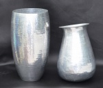 Dois vasos em alumínio martelado. Medidas 40 e 33 cm. Diâmetros 19 e 16,5 cm.
