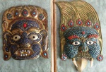 2 Máscaras em bronze com aplicação de pedras provenientes da Ásia . Mede : 20 x 17 cm.