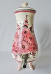 Antigo filtro de porcelana branca com decoração floral em tons rosa. Peça apoiada sobre 4 pés e numerada 435. Possui tampa colada. No estado. Medidas de 40cm de alt.