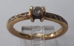 JÓIA DE OURO 18 K - Magnífico anel em ouro, com pedra maior central, e laterais cravejadas de brilhantes.  4,5 grs. Aro 16.