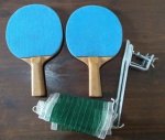 Jogo de tênis de mesa com duas raquetes emborrachadas em ambos os lados e rede com fixadores na mesa. (DC267)