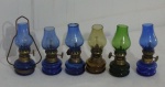 Coleção de Lampiões em miniatura manufaturada em vidro colorido, sendo azul, verde e translucida, corpo em metal dourado, cúpula de uma com quebrado, vide foto, Alt. 10cm