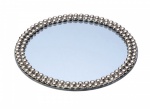 Bandeja redonda em metal prateado com bordas ricamente ornamentada e fundo espelhado. Medida; 25cm de diâmetro.
