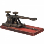 Peça decorativa remetendo a telegrafo antigo feita em metal com base em madeira. Medida 22x10 CM