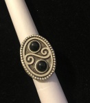 PRATA- Lindíssimo anel em prata de lei, decoração mística, composto por duas pedras centrais na cor preta. Aro ajustável.