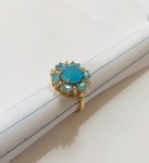 BIJUTERIA FINA- Lindíssimo anel representando flor, em metal dourado, cravejado por pedras na cor azul bebê Aro. 18/19
