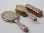 3 Peças para tocador em metal prateado, espelho e duas escovas. Comprimento do espelho 27 cm.