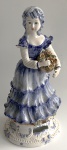Capodimonte - Escultura de cerâmica vitrificada nas tonalidades branco, azul e marrom, com imagem de figura feminina com cesto de flores, (Peça em ótimo estado de conservação) aprox. 48 x 23 cm de diâmetro na base