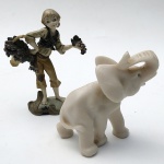 Lote 2 peças decorativas de material sintético sendo: Elefante e garoto com cachos de uvas, peça maior aprox. 16 x 12 cm