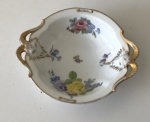 Rosenthal - Petisqueira de porcelana alemã na tonalidade branca com acabamento dourado, desenho floral e alças com cara de `Bode` (Obs. Apresenta bicado) aprox. 14,5 cm de diâmetro 